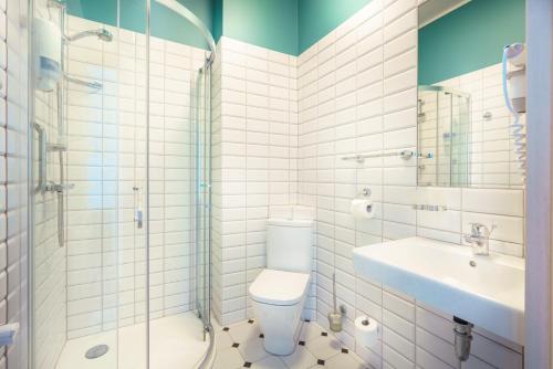 a bathroom with a toilet and a sink and a shower at Hotel Jarota in Jarocin