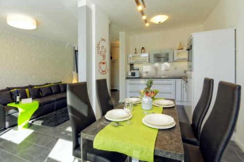 ein Esszimmer und eine Küche mit einem Tisch und Stühlen in der Unterkunft Kapitänsweg 2 Kajüte 05 in Ostseebad Karlshagen