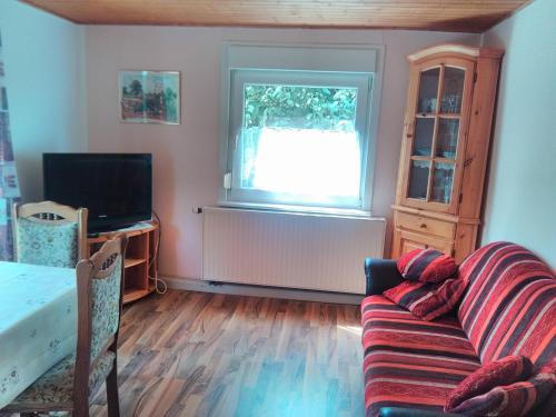 ein Wohnzimmer mit einem Sofa und einem Fenster in der Unterkunft Ferienpark Sonnenhof in Tambach-Dietharz