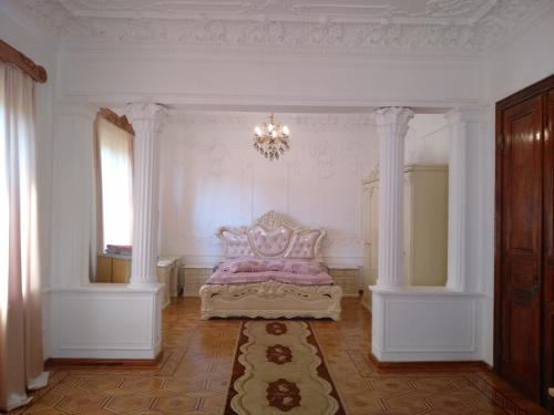 a bedroom with a bed in a room with a chandelier at Hotel Royal in Kutaisi