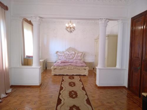 a large bedroom with a bed with a pink bedspread at Hotel Royal in Kutaisi
