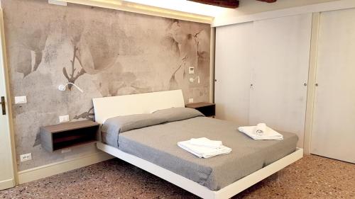 a bedroom with a bed and a concrete wall at Cà Riva del Vin in Venice