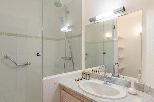 a bathroom with a sink and a shower and a mirror at La Pinède in Amélie-les-Bains-Palalda