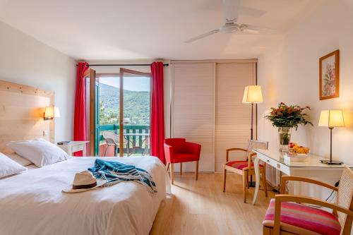 アメリー・レ・バン・パラルダにあるLa Pinèdeのベッド、デスク、窓が備わるホテルルームです。