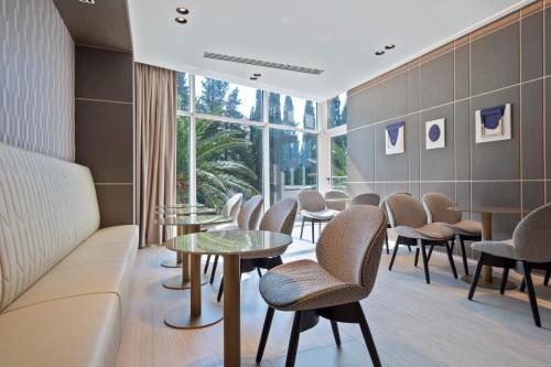 a waiting room with tables and chairs and a window at Hotel AMI Budva Petrovac in Petrovac na Moru