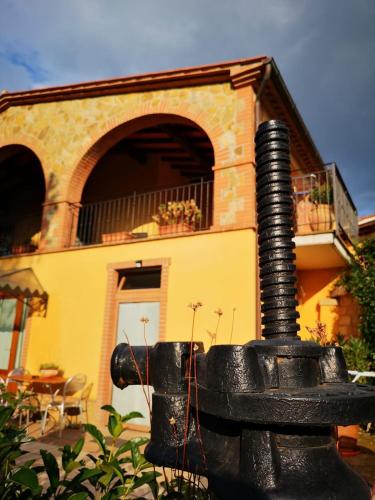 a black fire hydrant in front of a house at La Biocca in Poggio Murella