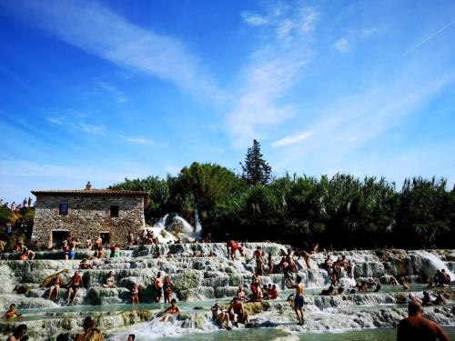 a group of people sitting in a waterfall at La Biocca in Poggio Murella