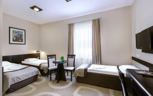 pokój hotelowy z 2 łóżkami i stołem z krzesłami w obiekcie Hotel Picaro Żarska Wieś Południe A4 kierunek Polska w mieście Zgorzelec