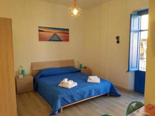 a bedroom with a bed with two towels on it at Casa Vacanze Vicè in Castellammare del Golfo