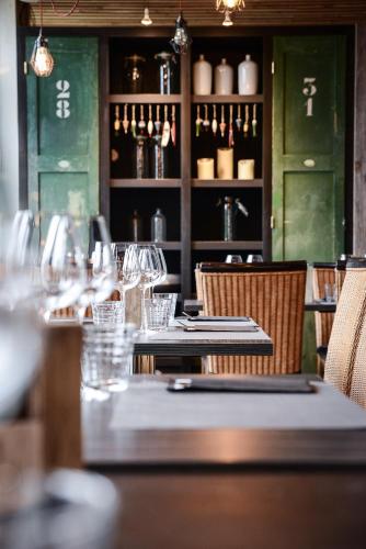 - un restaurant avec une table, des verres et des bouteilles de vin dans l'établissement La maison des pêcheurs, à Viviers-du-Lac