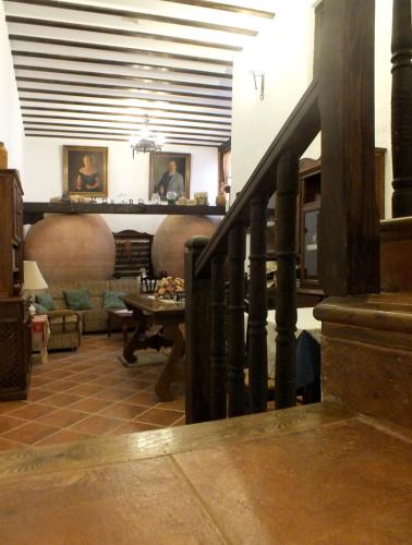 a living room with a staircase and a couch at Hotel Rural Posada Los Caballeros in Almagro