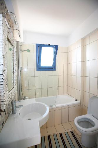 a bathroom with a sink and a tub and a toilet at Meltemi Villas in Paphos City
