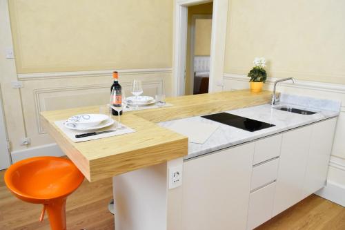 Una cocina con gabinetes blancos y una encimera de madera. en Stella Polare - Luxury apartment, en Lucca