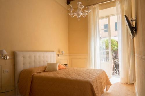 Schlafzimmer mit einem Bett, einem Fenster und einem Kronleuchter in der Unterkunft Stella Polare - Luxury apartment in Lucca