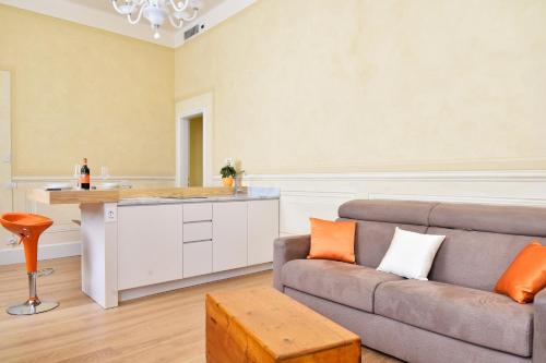 Una sala de estar con un sofá y una cocina. en Stella Polare - Luxury apartment, en Lucca