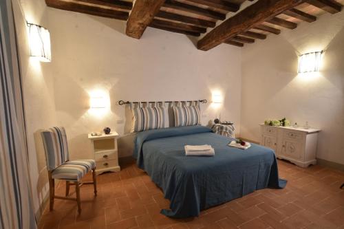 a bedroom with a blue bed and two chairs at Talacchio in Città di Castello