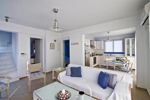 a living room with a white couch and a table at Meltemi Villas in Paphos City