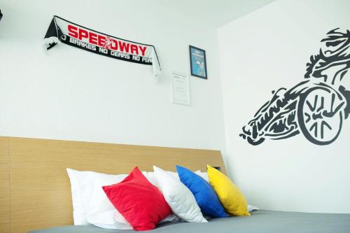 a bed with colorful pillows and a sign on the wall at Novotel Gdansk Centrum in Gdańsk