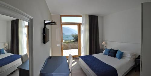 a bedroom with two beds and a view of the ocean at Tullio Hotel in Gravedona