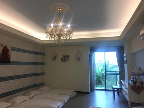 a bedroom with two beds and a chandelier at 來嘉小棧 in Chiayi City