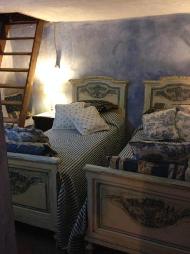 a bedroom with two beds and a ladder at Il Priorato in Pescia