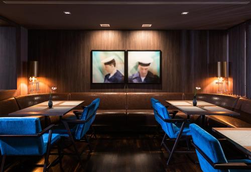 a dining room with tables and blue chairs at AMERON Hamburg Hotel Speicherstadt in Hamburg