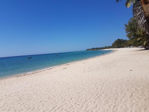 a sandy beach with the ocean in the background at Hotel Wimbi Sun in Pemba