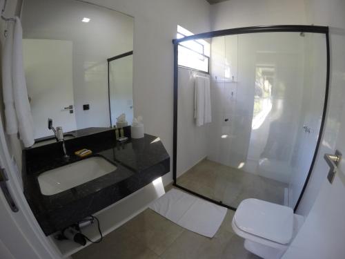 a bathroom with a shower and a sink and a toilet at Luz da Lua Pousada in Ubatuba