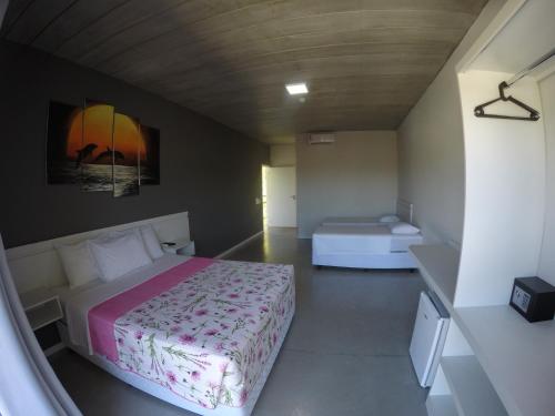 a small bedroom with a bed at Luz da Lua Pousada in Ubatuba