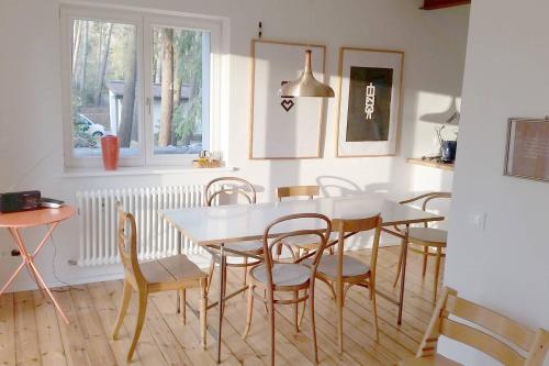 une salle à manger avec une table et des chaises blanches dans l'établissement Ferienhaus Bindow, à Bindow Siedlung