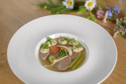 a bowl of soup with shrimp and vegetables on a plate at Au Bivouac de Napoléon et Spa in Bourg-Saint-Pierre
