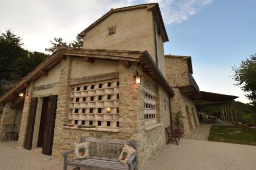 a stone building with a bench in front of it at Talacchio in Città di Castello