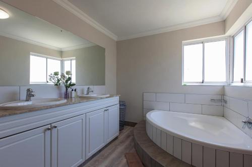 a white bathroom with a large tub and two sinks at position, Position, POS-ITION! Adjacent CB Beach in Cape Town
