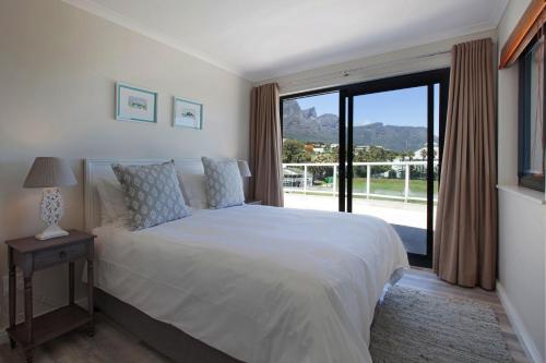 a bedroom with a bed and a large window at position, Position, POS-ITION! Adjacent CB Beach in Cape Town