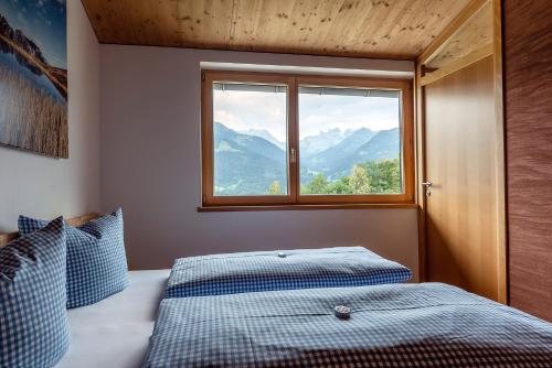 バルトロメベルクにあるHaus Idaのベッドルーム1室(ベッド1台付)、山の景色を望む窓が備わります。