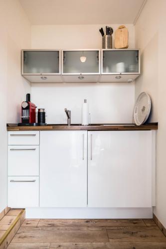 a kitchen with white cabinets and a counter top at Hotel zur Mühle in Paderborn