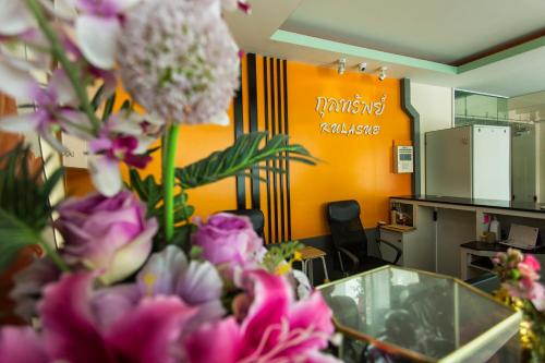 a bunch of pink flowers in an office at Kulasub Hotel in Hat Yai