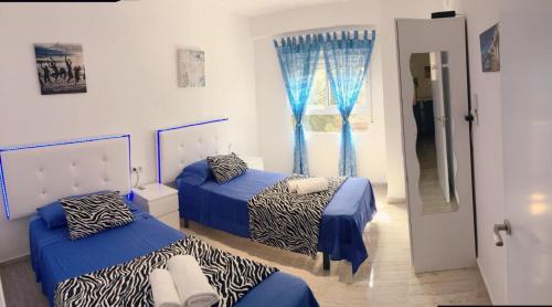 バレンシアにあるBella Vistaのベッドルーム1室(ベッド2台、青いカーテン付きの窓付)