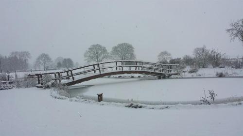 a bridge over a body of water in the snow at Urlaubsdomizil im Grünen in Westerstede