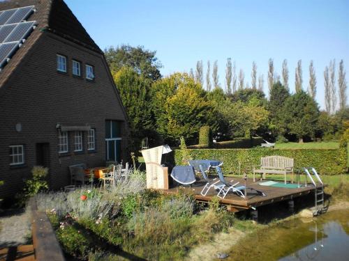 a house with a dock with chairs and a table at Urlaubsdomizil im Grünen in Westerstede