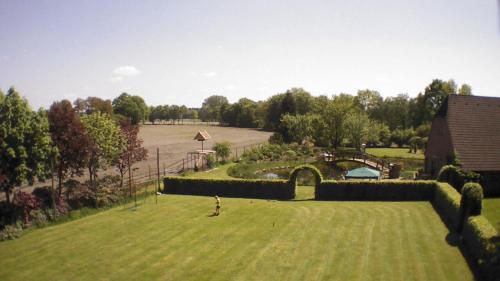 a large green yard with a bridge and a pond at Urlaubsdomizil im Grünen in Westerstede
