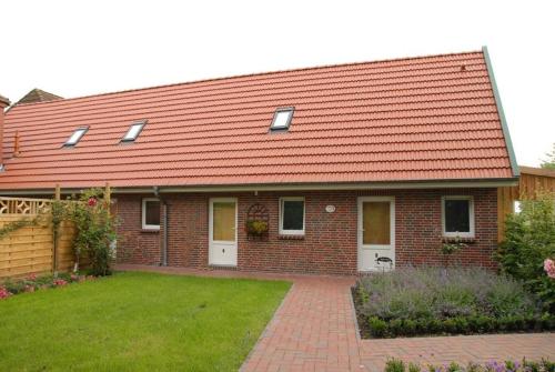 a brick house with a red roof and a yard at Urlaubsdomizil im Grünen in Westerstede