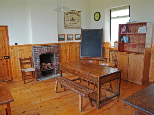 a classroom with a table and a fireplace at The Old School in Ballyheigue