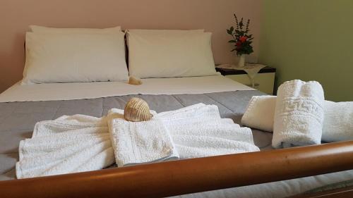 a bed with towels and pillows on it at Villa Xani in Himare