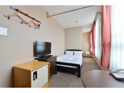 a hotel room with a bed and a tv at A-GATE Hotel Hakodate in Hakodate