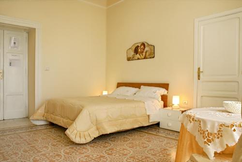 1 dormitorio con 1 cama, 1 mesa y 2 lámparas en Bed and Breakfast Sommavesuvio, en Pollena Trocchia