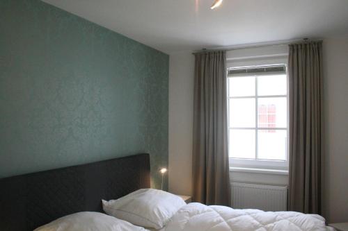 a bedroom with a bed and a window at Haus Meeresblick FeWo Duenenzauber in Baabe