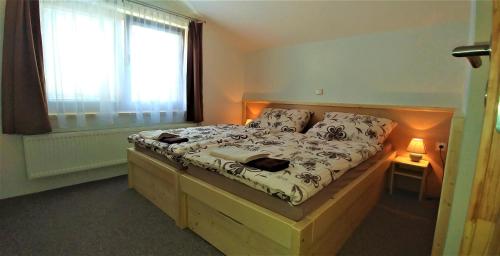 チェスキー・クルムロフにあるPenzion U Médiのベッドルーム1室(木製ベッド1台、窓付)