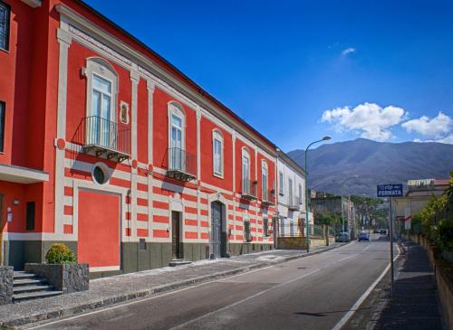een rood-wit gebouw aan de straatkant bij Bed and Breakfast Sommavesuvio in Pollena Trocchia