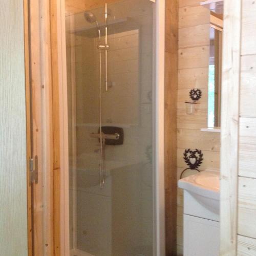 une douche en verre dans une salle de bain avec un lavabo dans l'établissement au moulin, à Esbareich